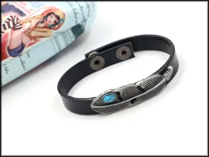 Detail eines Bohème-Lederarmbands mit silberner Feder und eingelegtem Türkisstein