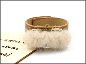 Detailed macro of wide brown leather bracelet with beige faux fur and gold buckle