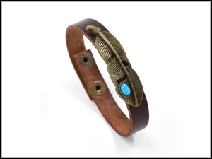 Details des Lederarmbands mit bronzener Feder und blauem Türkis-Stein-Verzierung