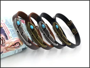Detail von Vintage-Lederarmbändern mit Federn und Türkis auf einem blauen Zylinder