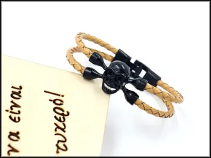 Makroansicht des kamelbraunen Lederarmbands mit mattschwarzem Totenkopf und Knochen-Anhänger