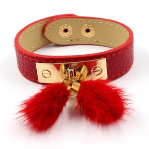 Red PU leather bracelet featuring gold turn-lock buckle and two plush faux fur balls