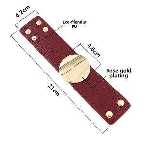 Detail of wide burgundy PU leather cuff with a polished rose gold round metal plate