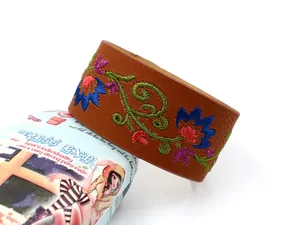 Detalle de bordado de flores coloridas en un brazalete ancho de cuero PU marrón