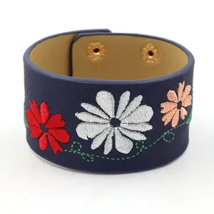 Navy blue PU leather wide cuff bracelet with colorful floral embroidery and gold snap buttons