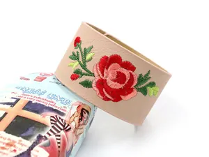 Detail der roten Rosenstickerei auf einem breiten Boho-Armreif aus hochwertigem Kunstleder