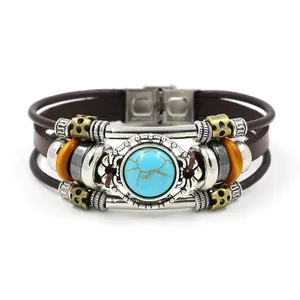 Bracelet multicouche en cuir bohème avec pierre turquoise et perles en métal sur fond blanc