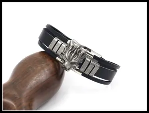 Primer plano de una pulsera de cuero punk con una cabeza de dragón de plata sobre madera