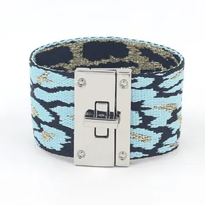 Detail van de geweven armband met luipaardprint en een zilverkleurige draaisluiting