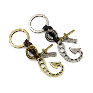 Detail of vintage hand-woven leather keychains with bronze and silver cross pendants