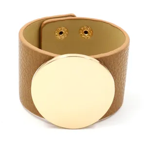 Street style wide tan leather cuff bracelet featuring a large polished gold metal disk