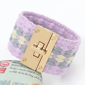 Detail van een geweven PU-leren armband met een gouden metalen draaisluiting