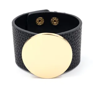 Wide black litchi leather cuff bracelet with a large polished gold round metal plate