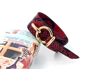 Détail du bracelet large en cuir PU motif serpent rouge avec un fermoir doré rond