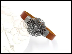 Macro detail of brown leather bracelet with vintage silver mandala floral ornament