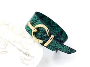 Gros plan du bracelet en cuir PU motif serpent vert avec grande boucle en métal doré