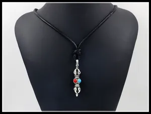 Macro detail of Vajra pendant with red and blue beads on black woven cord necklace