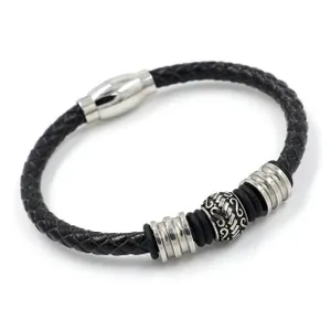 Dettaglio del bracciale in pelle nera intrecciata con perline incise e chiusura magnetica