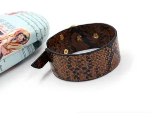 Vue détaillée du bracelet en cuir serpent avec boutons-pression dorés réglables