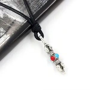 Ethnic Vajra pendant with red and blue beads on a black woven cord, bohemian style
