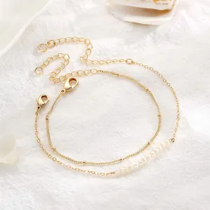 Detail of 18K gold-plated double-layer chain bracelet featuring baroque pearls and beads