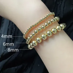 Detail view of 18K gold beaded bracelets in 4mm, 6mm, and 8mm sizes on a wrist