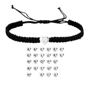 Detail of adjustable black woven bracelet with silver heart charm and full alphabet set