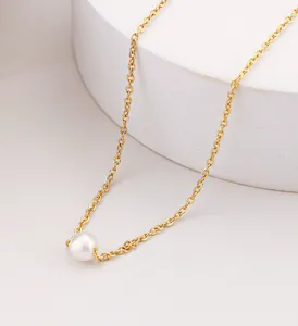 Detailed view of single round white pearl on elegant 18K gold plated stainless steel chain