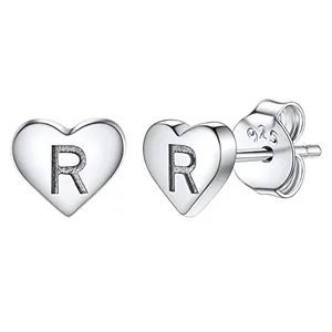 Detail of silver heart stud earrings with engraved letter R and 925 silver hallmark