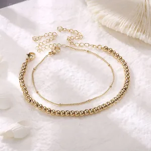 Detail of gold layered chain bracelet set with lobster clasp and extension on white coral