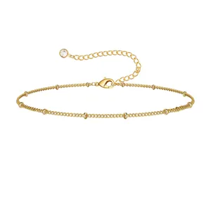 Detail of gold bead chain anklet with lobster clasp and clear zircon stone pendant