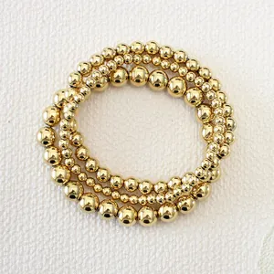 Close-up of layered 18K gold-plated stainless steel bead bracelets in 4mm 6mm and 8mm sizes
