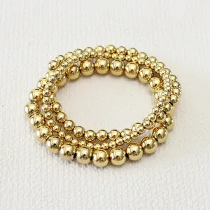 Close-up of three 18K gold-plated stainless steel bead bracelets with varying bead sizes