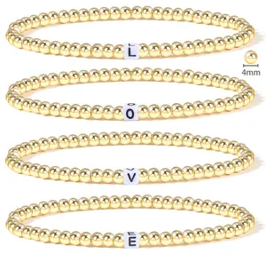 Detail of 4mm 18K gold beaded stretch bracelets set featuring LOVE letter cubes