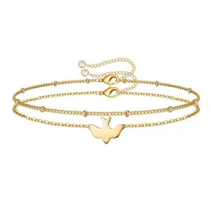 Close-up of triple-layered 18K gold-plated bracelet with a bird charm and lobster clasp