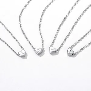 Detail of four stainless steel heart necklaces with engraved L O V E letters