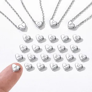 Detailed macro view of heart-shaped stainless steel letter charms L, O, V, E on chain