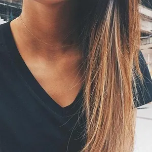 Detail of 18K gold-plated double-layer bead chain necklace on woman's neck