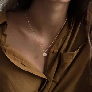 Detail of 18K gold-plated double-layer necklace with personalized letter K round pendant