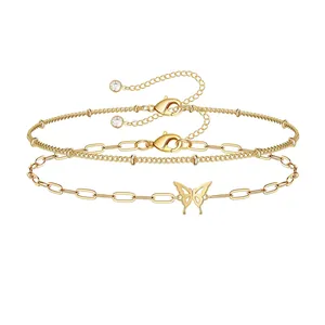 Detail van 18K vergulde dubbellaagse armband met paperclipketting en vlinderhanger