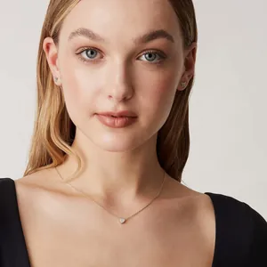 Detail of elegant heart necklace and butterfly studs worn on model for daily wear