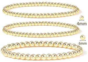 Detail view of 4mm and 6mm 18K gold plated beaded elastic bracelets in a 3-piece set