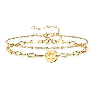 Detailed view of triple gold-plated paperclip chain set with a paw print charm and beads