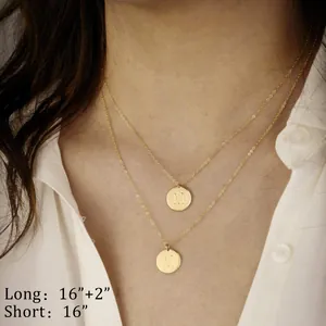 Detail of double-layer gold necklace featuring 16 and 18 inch chains with 'M' pendants