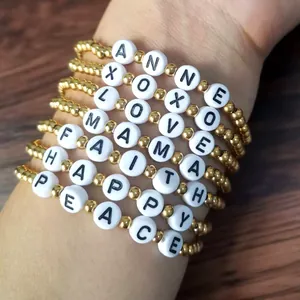 Stack of 18K gold beaded elastic bracelets with personalized white letter beads set