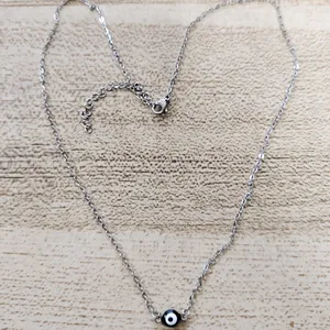 Detail of adjustable evil eye pendant necklace with lobster clasp on wooden background