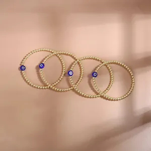 Detailed close-up of four-piece gold beaded evil eye bracelets set on elegant background