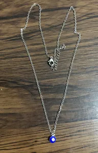 Detail of blue evil eye pendant with silver chain and adjustable lobster clasp