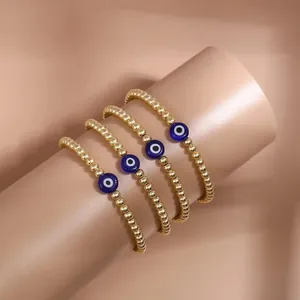 Close-up of four gold beaded Evil Eye bracelets stacked on a display stand