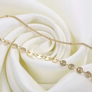 Detailed macro view of 18K gold plated double layer beaded chain on white silk background
